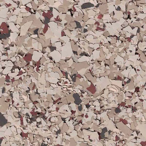 A close-up of a surface featuring irregularly shaped, scattered fragments in beige, brown, and black, resembling textured terrazzo or concrete flooring.